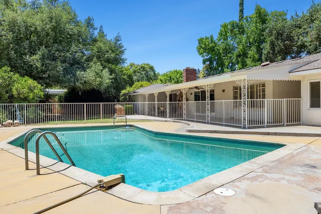 an aerial view of a house with a yard and swimming pool