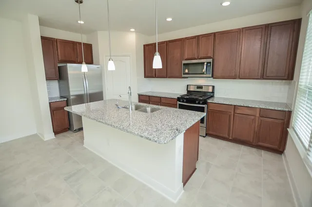a kitchen with a sink chandelier and refrigerator