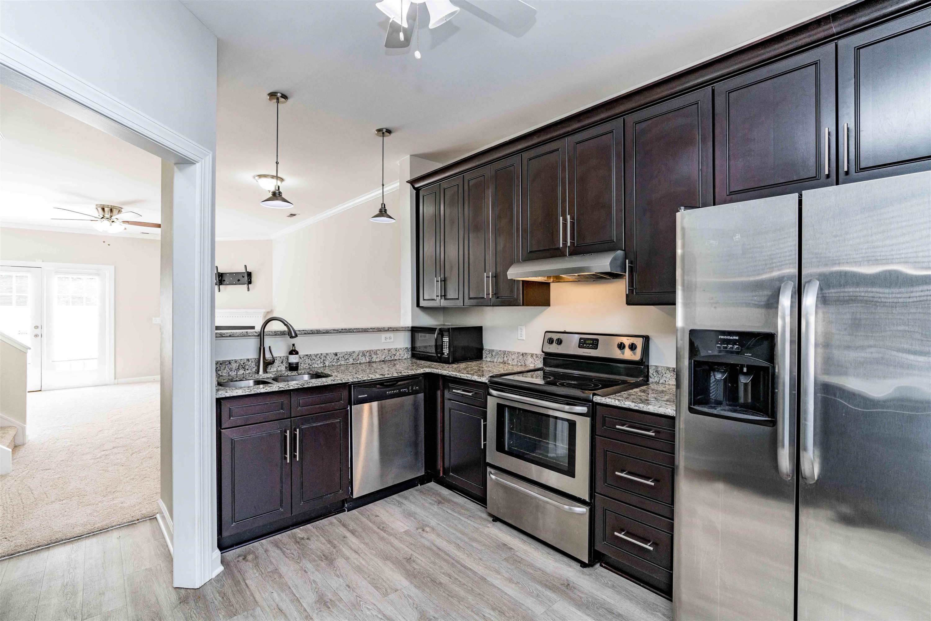 807 Rothshire Court Raleigh, NC 27615 - Photo 4 of 25 a kitchen with kitchen island granite countertop wooden cabinets stainless steel appliances and a counter space