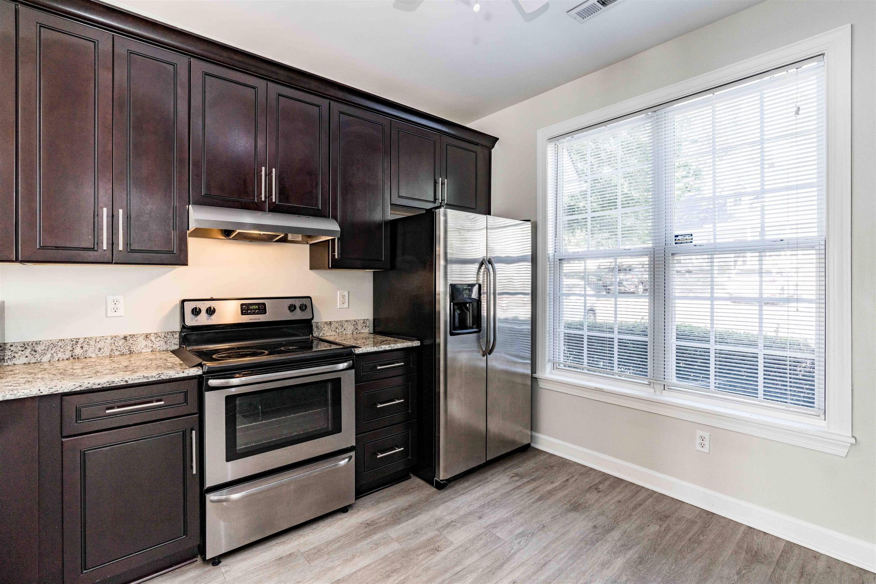 807 Rothshire Court Raleigh, NC 27615 - Photo 5 of 25 a kitchen with granite countertop wooden cabinets and stainless steel appliances
