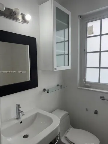 a bathroom with a toilet sink and mirror