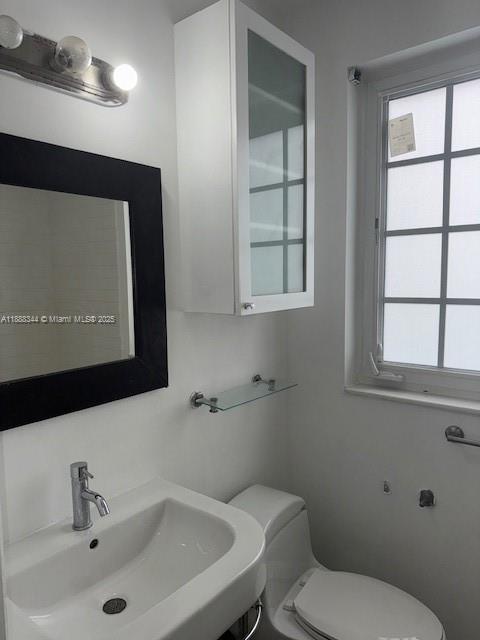 439 15th Street, Unit 9 Miami Beach, FL 33139 - Photo 4 of 11 a bathroom with a toilet sink and mirror