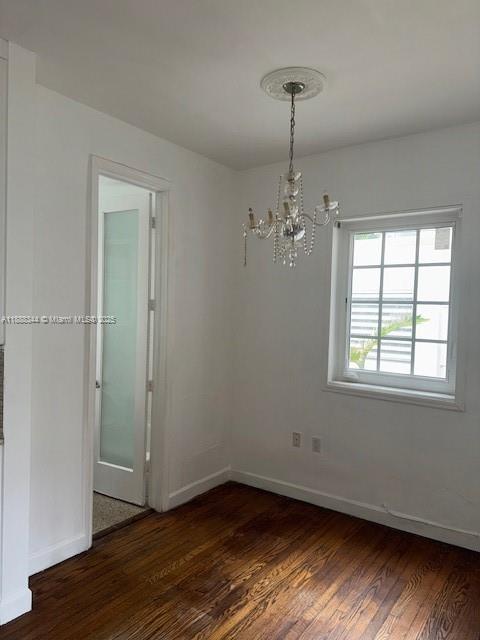 439 15th Street, Unit 9 Miami Beach, FL 33139 - Photo 6 of 11 an empty room with wooden floor chandelier and windows