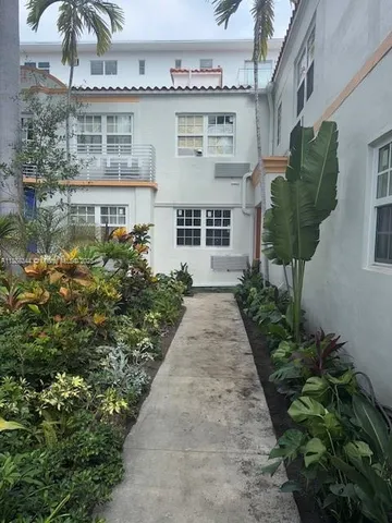 a front view of a house with a yard and fountain in middle of house