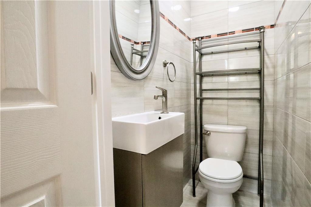 24 Wendover Road Queens, NY 11375 - Photo 12 of 34 a bathroom with a sink a toilet and a mirror