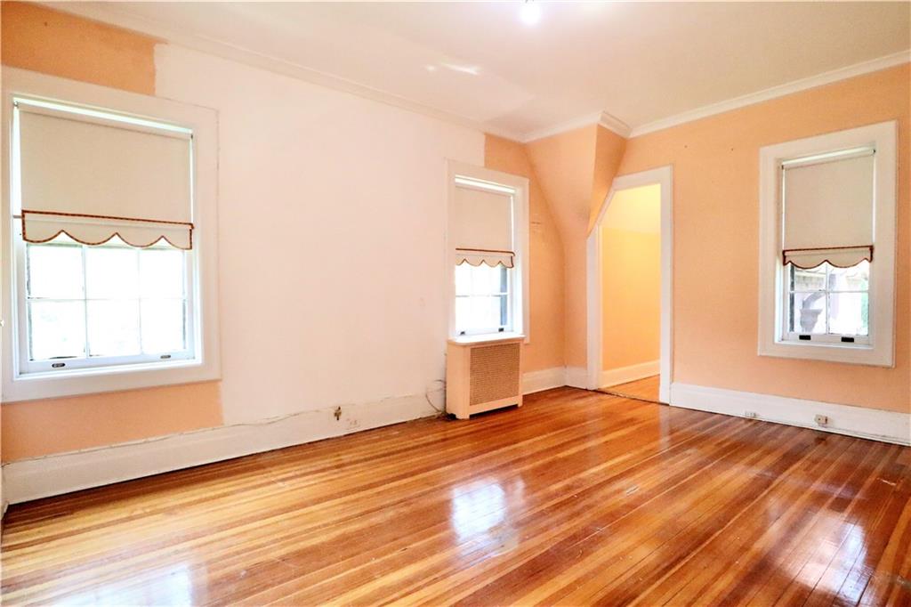 24 Wendover Road Queens, NY 11375 - Photo 14 of 34 an empty room with wooden floor and windows