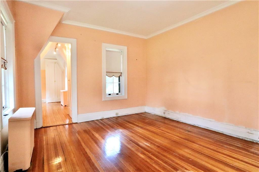 24 Wendover Road Queens, NY 11375 - Photo 15 of 34 a view of an empty room with wooden floor and a window