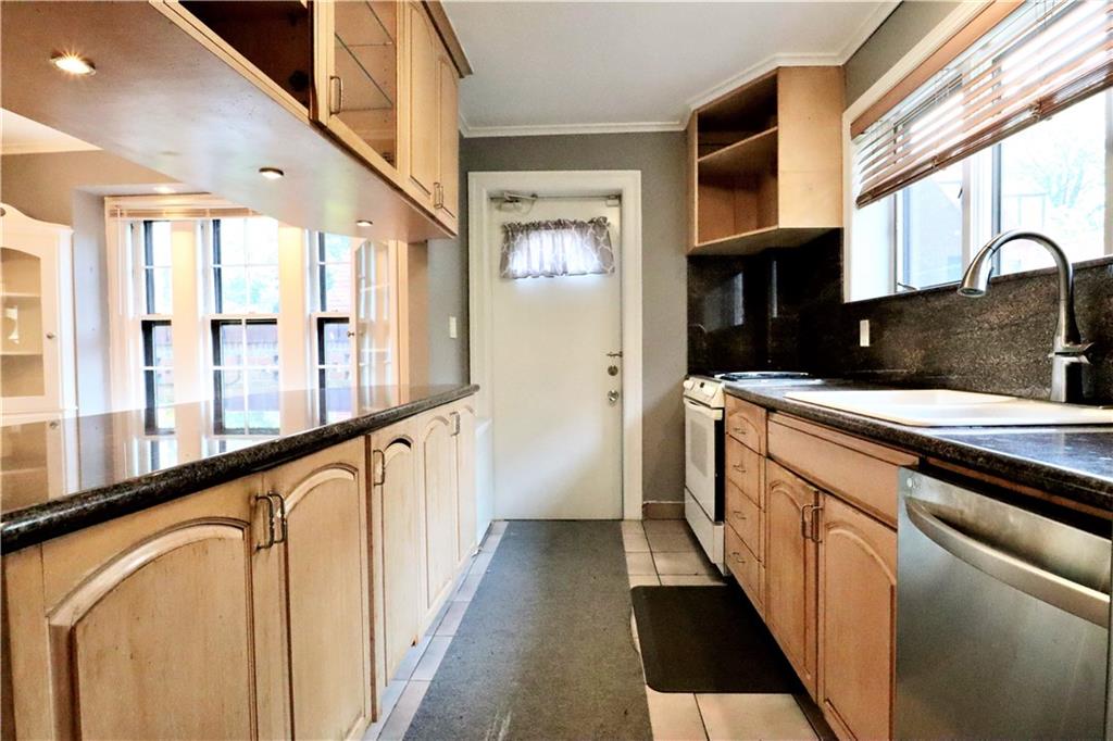 24 Wendover Road Queens, NY 11375 - Photo 10 of 34 a hallway with white cabinets and black stainless steel appliances