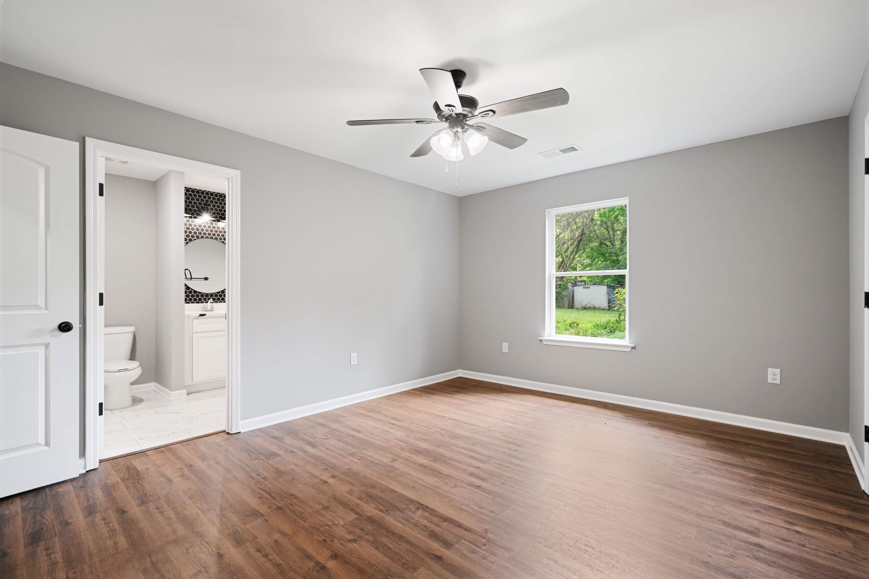 3766 Grey Road Memphis, TN 38108 - Photo 3 of 12 an empty room with wooden floor fan and windows