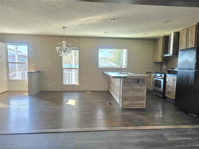 an open kitchen with stainless steel appliances granite countertop a stove and a refrigerator