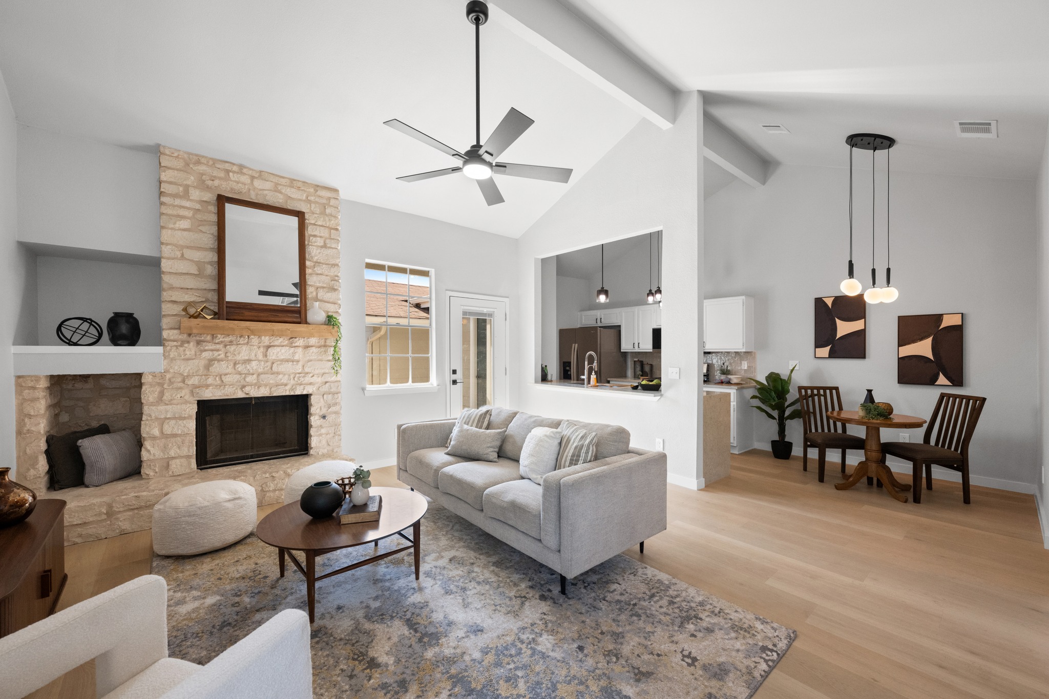 6501 Brush Country Road, Unit 120 Austin, TX 78749 - Photo 1 of 26 Welcome home to this spacious living area featuring a stunning stone-clad fireplace, vaulted ceilings with exposed beams, brand-new LVP flooring, and a large pass-through window that seamlessly connects to the kitchen.