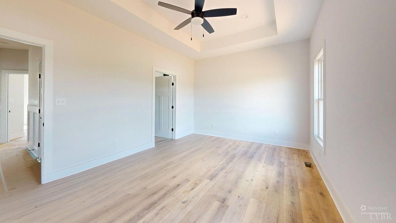 766 Moorman Mill Road Rustburg, VA 24588 - Photo 29 of 42 an empty room with wooden floor and ceiling fan