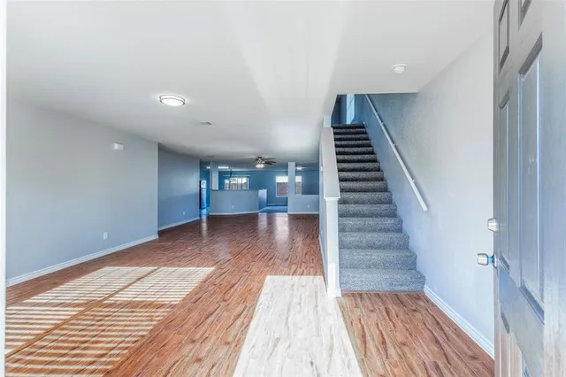 a view of a hallway with wooden floor and staircase