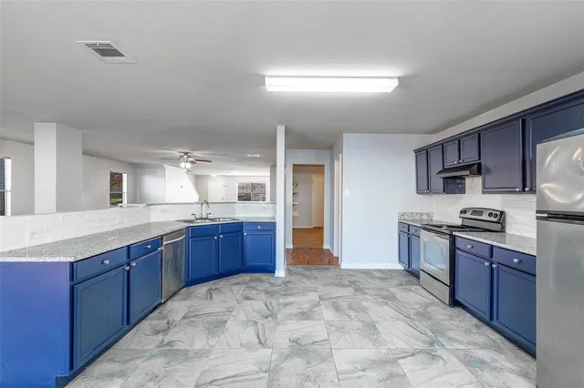 a large kitchen with stainless steel appliances lots of counter top space