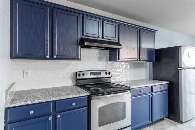 a kitchen with granite countertop wooden cabinets and a stove top oven