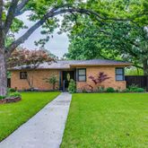 a front view of a house with a garden and yard