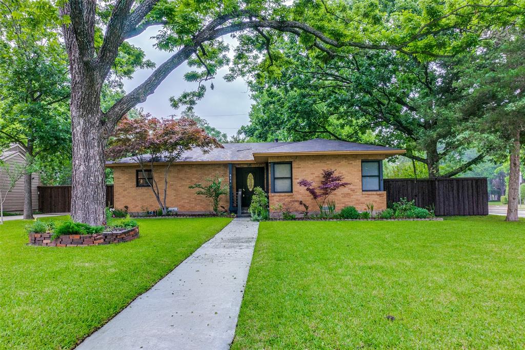 a front view of a house with a garden and yard