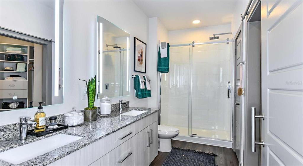 1040 Jamison Loop, Unit REVIVE Kissimmee, FL 34744 - Photo 13 of 18 a bathroom with a granite countertop sink toilet and shower