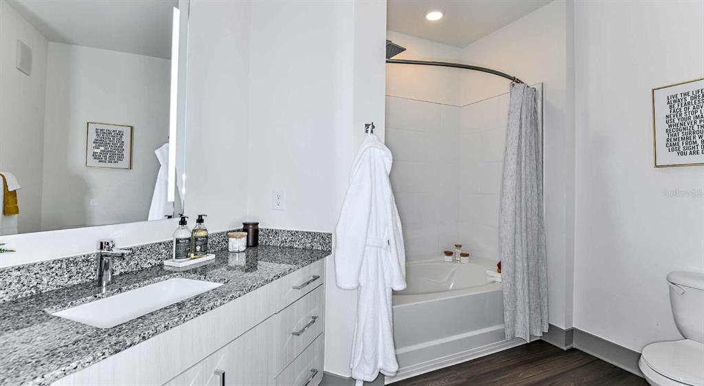 1040 Jamison Loop, Unit REVIVE Kissimmee, FL 34744 - Photo 16 of 18 a bathroom with a tub sink and mirror