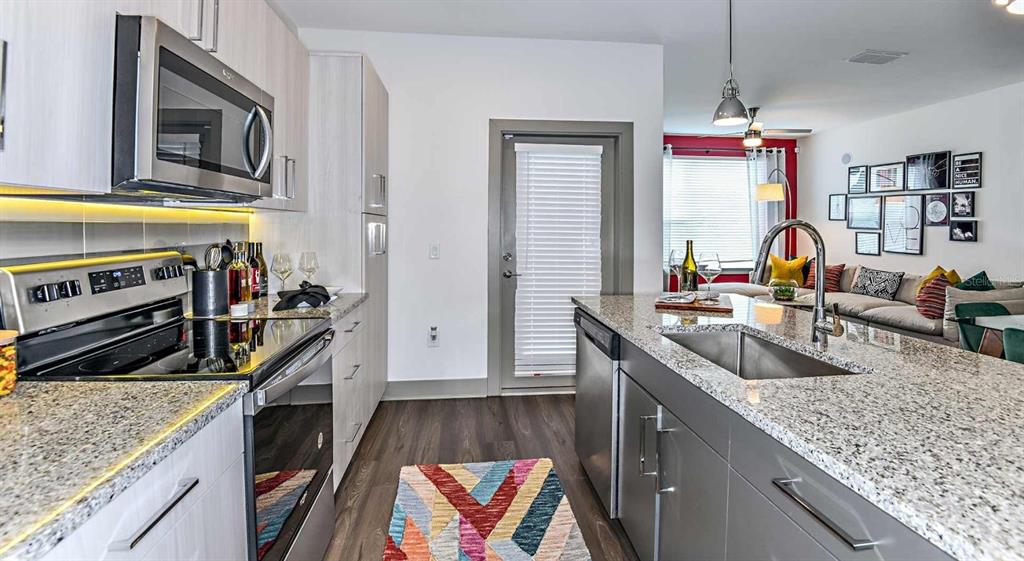 1040 Jamison Loop, Unit REVIVE Kissimmee, FL 34744 - Photo 6 of 18 a kitchen with stainless steel appliances granite countertop a sink stove and refrigerator