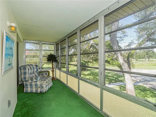 a view of front door with lawn chairs and iron fence