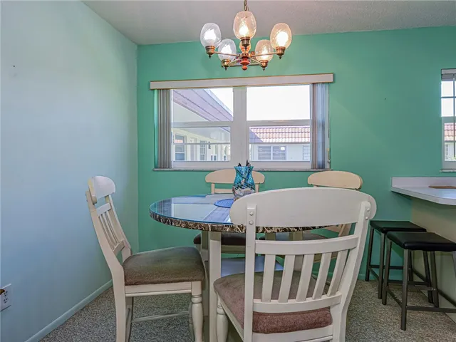 a view of a dining room with furniture a chandelier and window