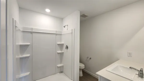 a bathroom with a toilet a sink and shower