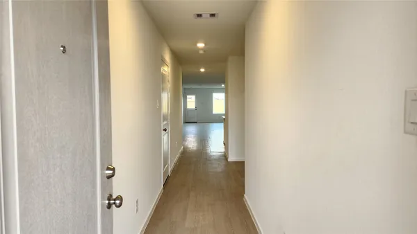 a view of a hallway with wooden floor