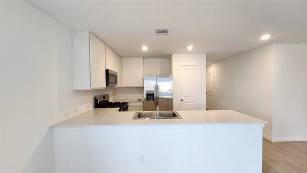 a kitchen with kitchen island a sink stainless steel appliances and cabinets