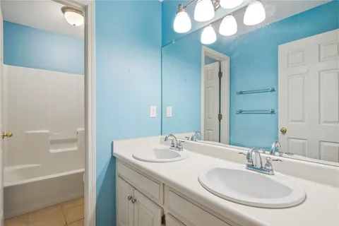 a bathroom with a sink a large mirror and a bathtub