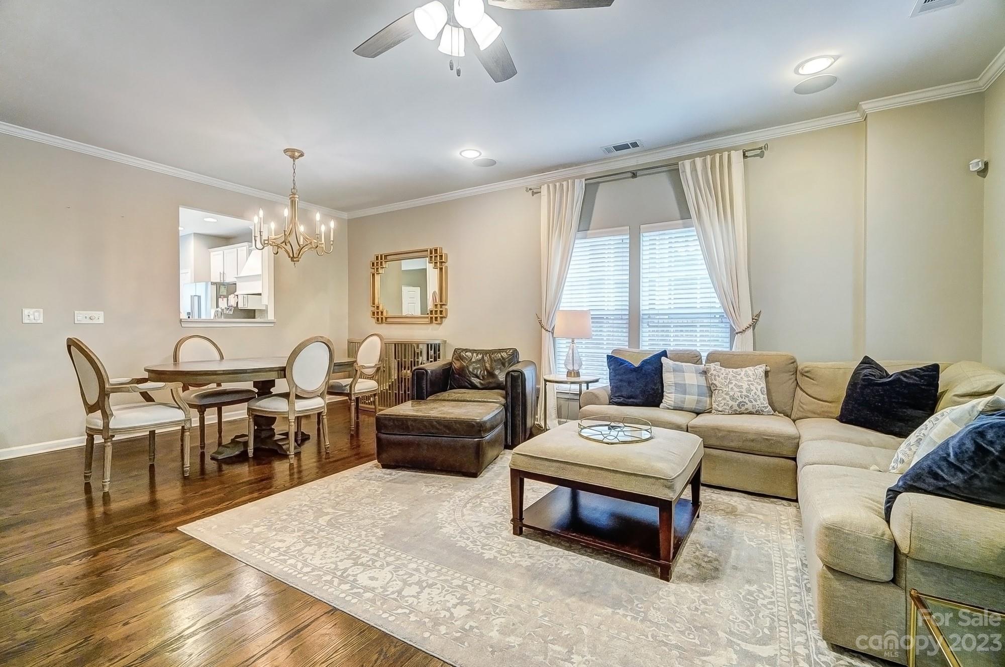 231 Lincoln Street Charlotte, NC 28203 - Photo 15 of 48 a living room with furniture a chandelier and a dining table
