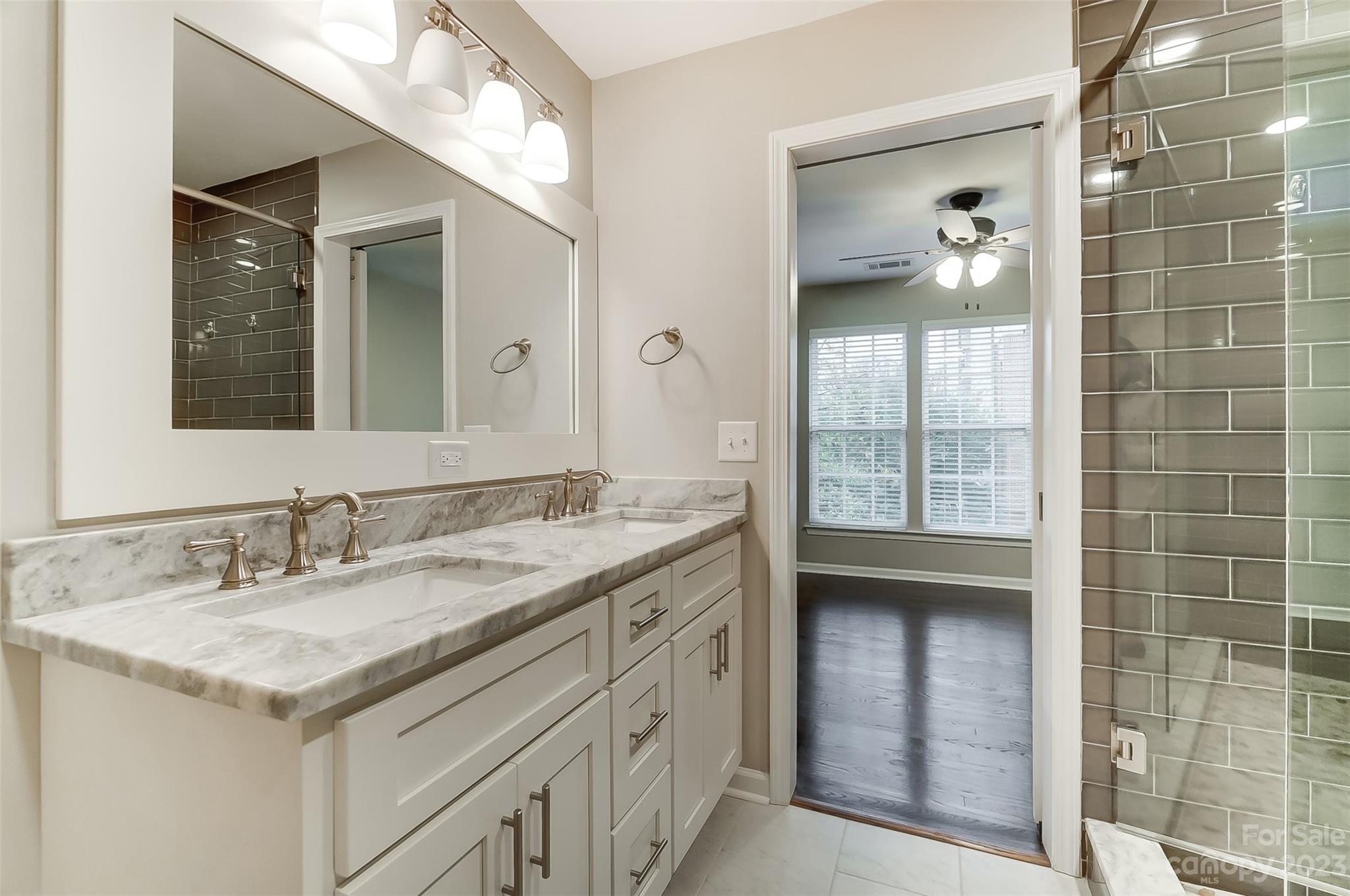 231 Lincoln Street Charlotte, NC 28203 - Photo 35 of 48 a bathroom with a granite countertop sink a large mirror and a shower