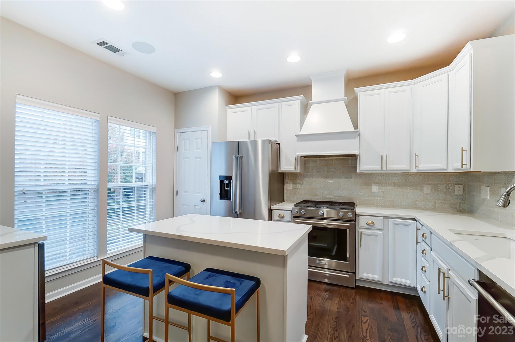 231 Lincoln Street Charlotte, NC 28203 - Photo 8 of 48 a kitchen with a stove a refrigerator a sink dishwasher with a dining table and wooden floor