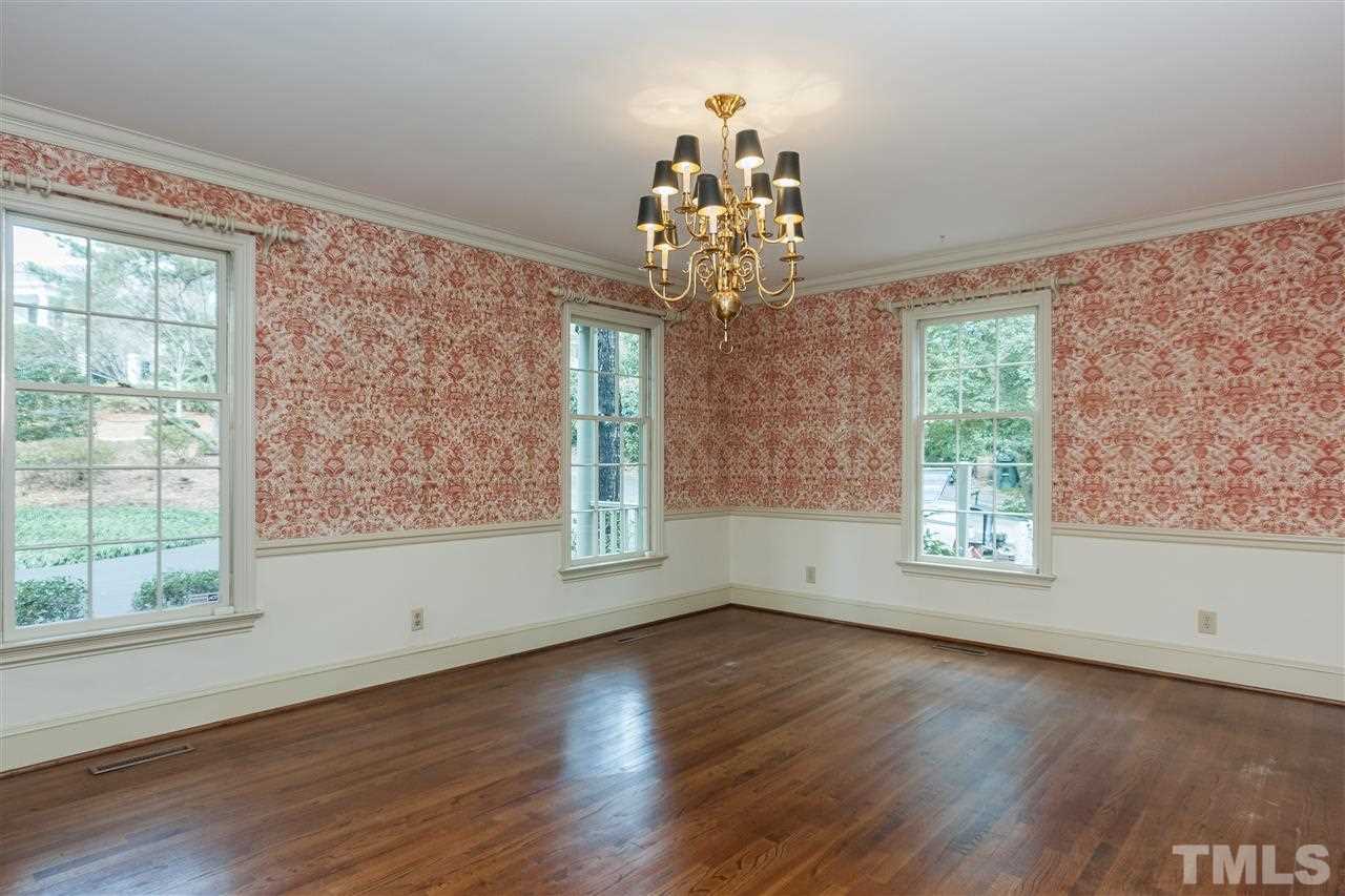 3400 Landor Road Raleigh, NC 27609 - Photo 6 of 25 an empty room with wooden floor chandelier and windows