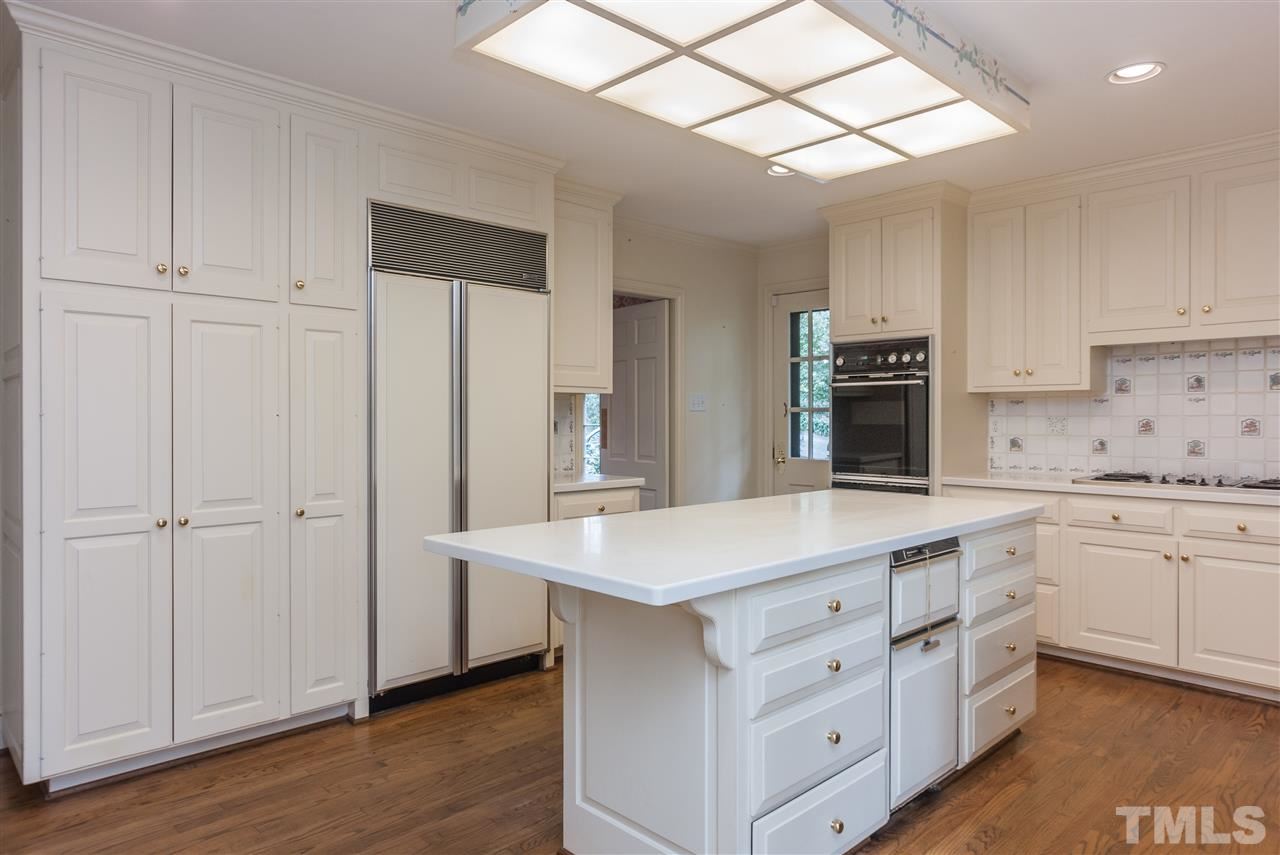 3400 Landor Road Raleigh, NC 27609 - Photo 10 of 25 a kitchen with kitchen island white cabinets and white appliances