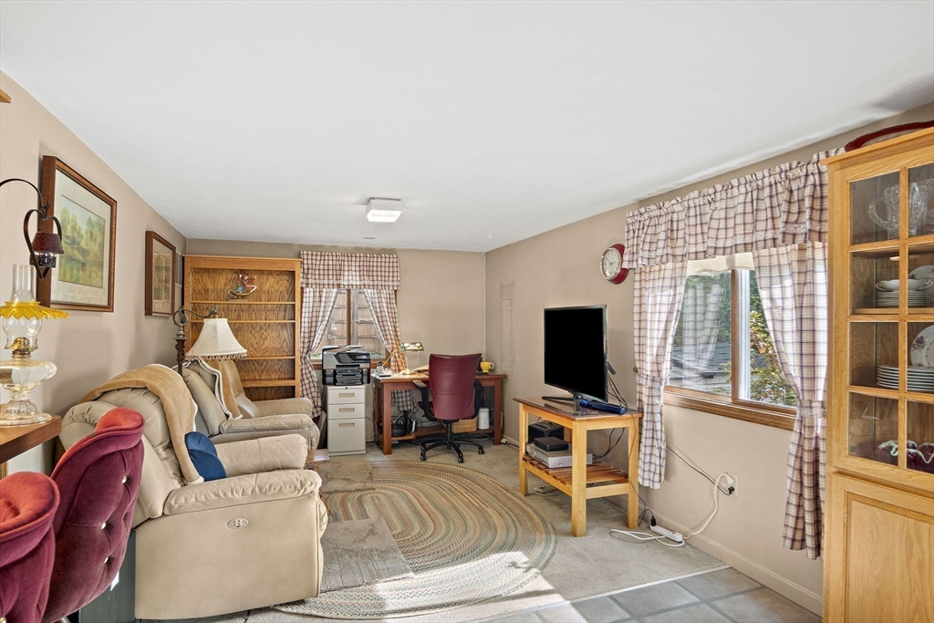 21 Kelsey Road Natick, MA 01760 - Photo 16 of 34 a living room with furniture a flat screen tv and a floor to ceiling window