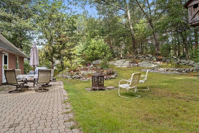 a backyard of a house with table and chairs