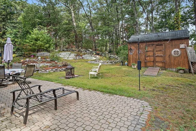 a view of a house with a big yard and large trees
