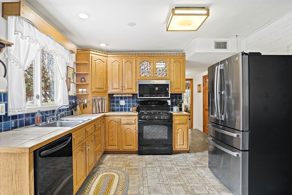 21 Kelsey Road Natick, MA 01760 - Photo 8 of 34 a kitchen with stainless steel appliances granite countertop a refrigerator and a sink