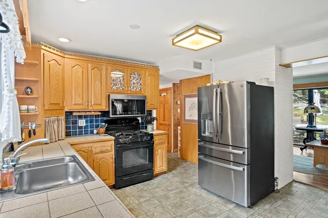 a kitchen with stainless steel appliances granite countertop a refrigerator and a sink