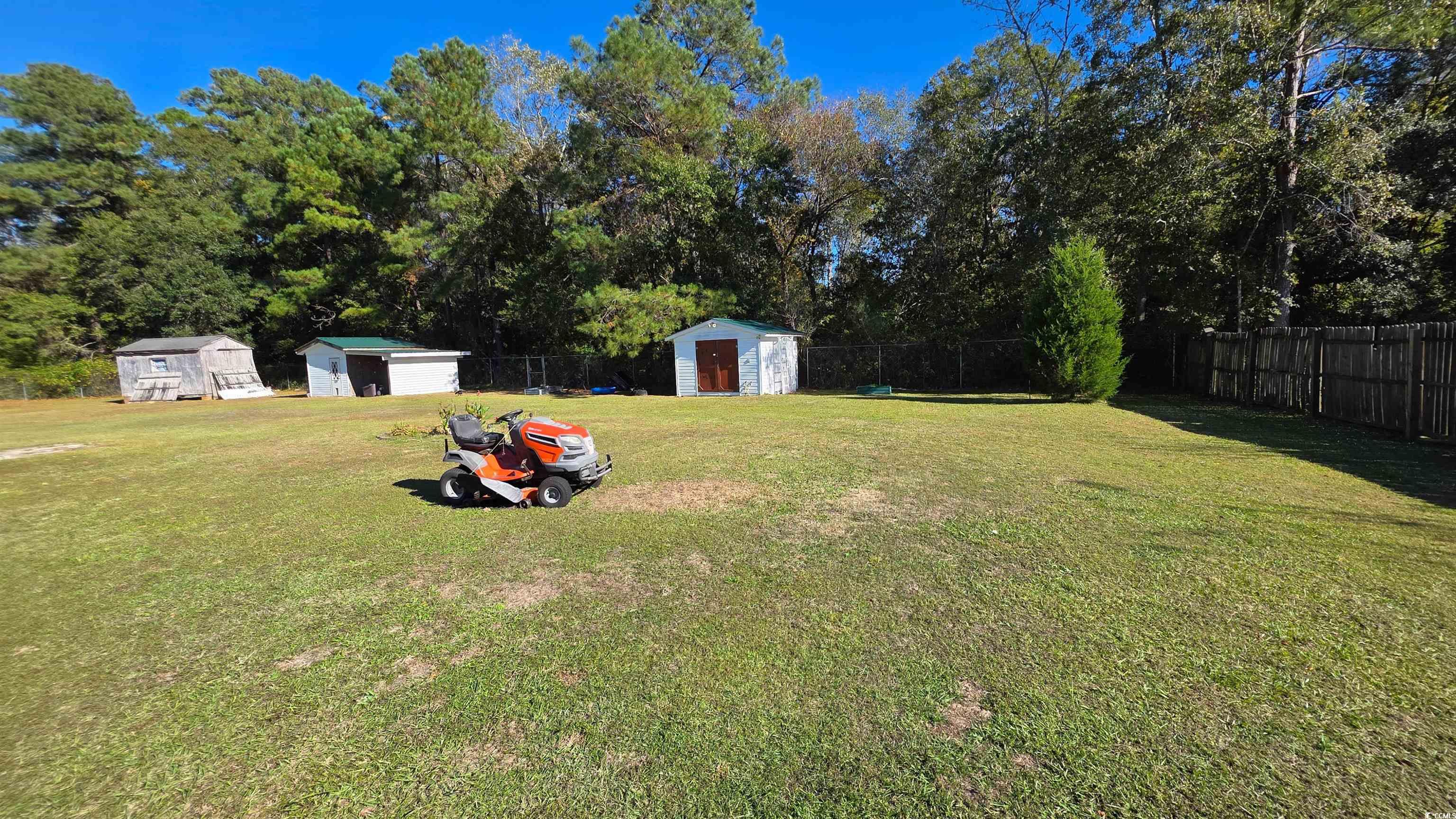 2018 Venus Court Loris, SC 29569 - Photo 16 of 17 Fenced backyard featuring a storage shed and view of scattered trees