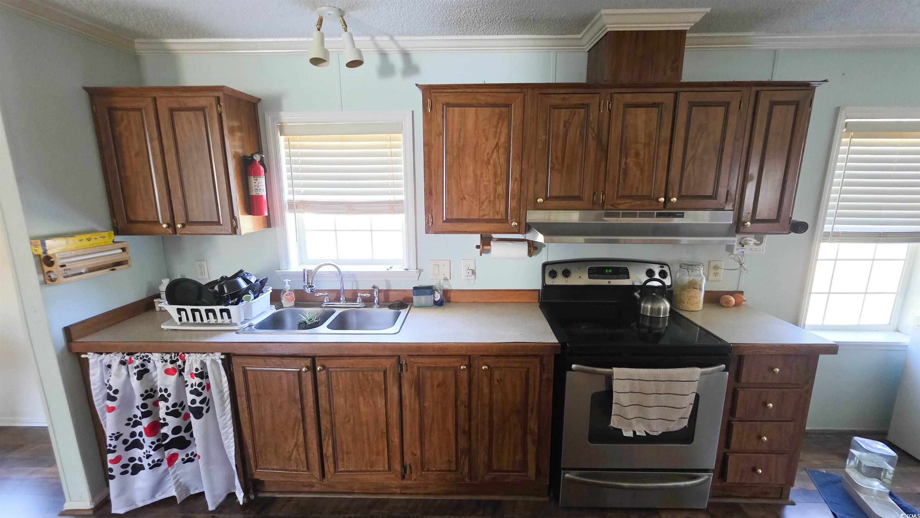 2018 Venus Court Loris, SC 29569 - Photo 5 of 17 Kitchen with stainless steel electric range, light countertops, a textured ceiling, crown molding, and under cabinet range hood