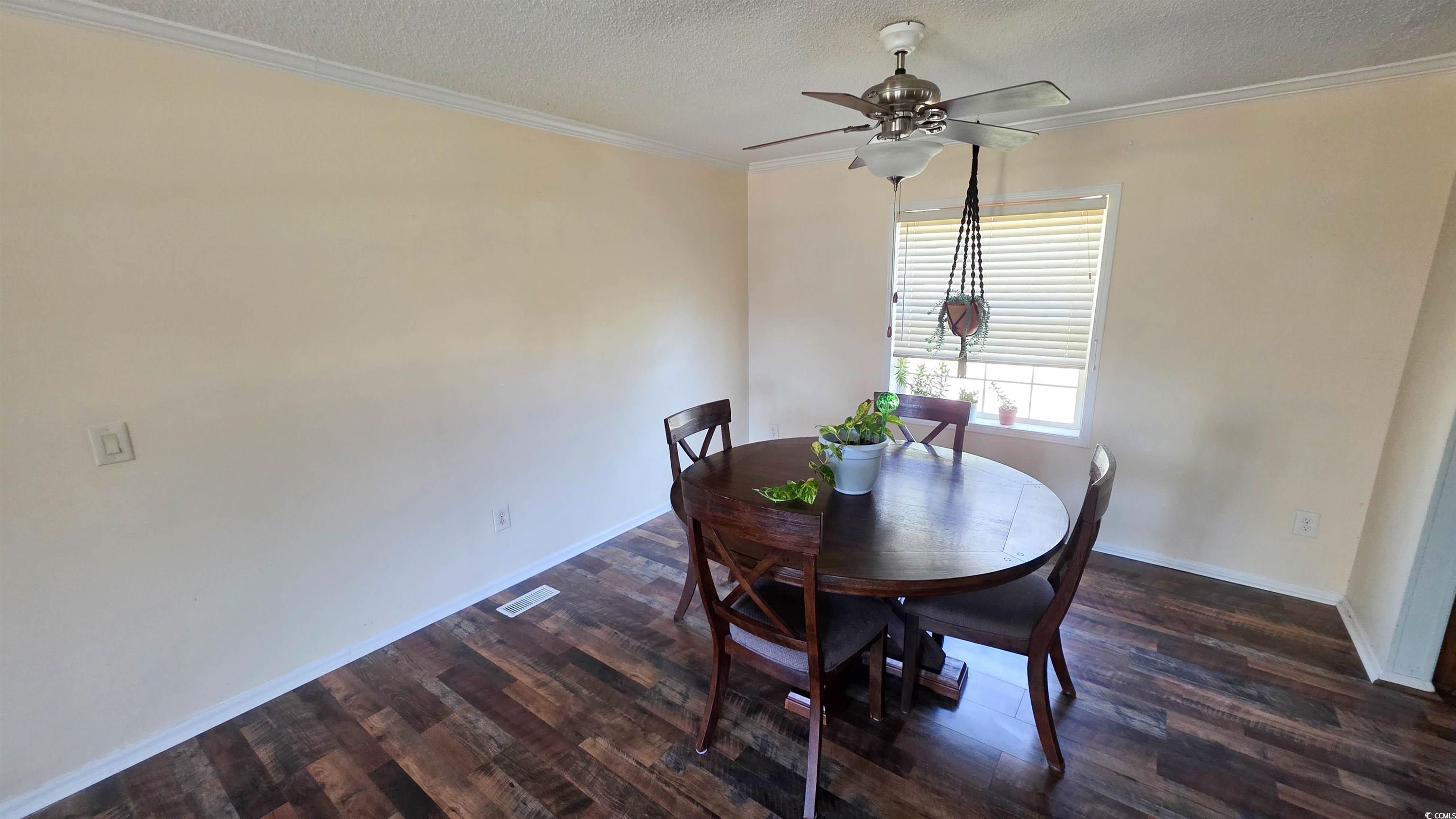 2018 Venus Court Loris, SC 29569 - Photo 6 of 17 Dining room featuring ornamental molding, a textured ceiling, dark wood-style flooring, and ceiling fan