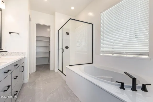 a bathroom with a tub sink and mirror