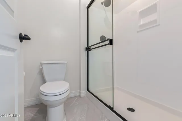 a bathroom with a toilet and a shower