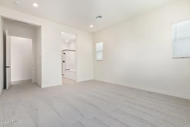 an empty room with a bathroom and mirror