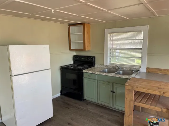a kitchen with a refrigerator and a sink
