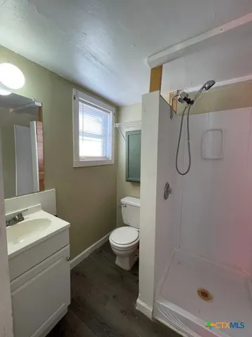 a bathroom with a granite countertop sink toilet and shower
