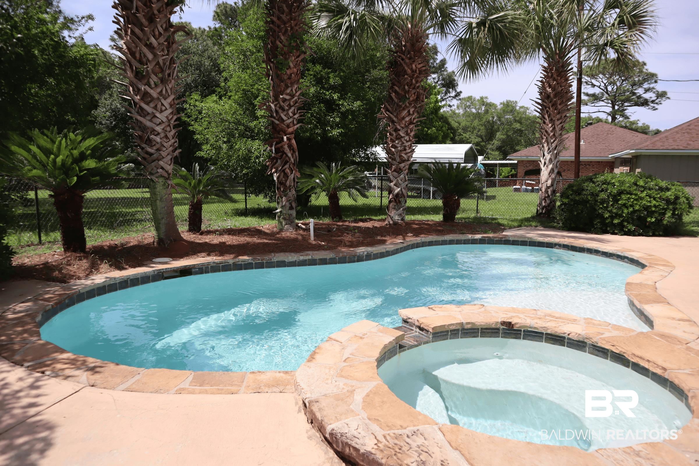 12150 Lee Bishop Road Irvington, AL 36544 - Photo 3 of 26 View of swimming pool with a pool with connected hot tub and fence