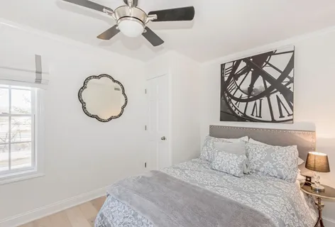 a bedroom with a bed and a painting on the wall